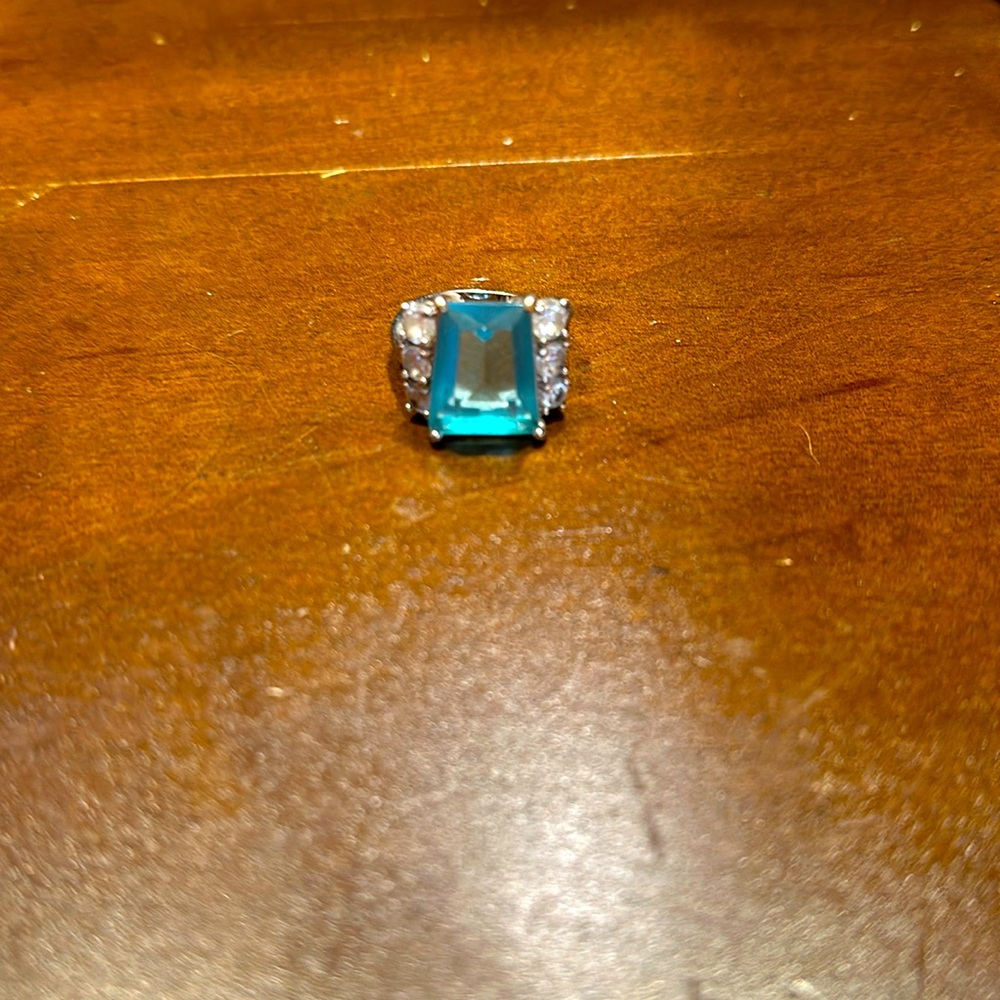 Beautiful women’s ring with turquoise center stone with cz on the side.